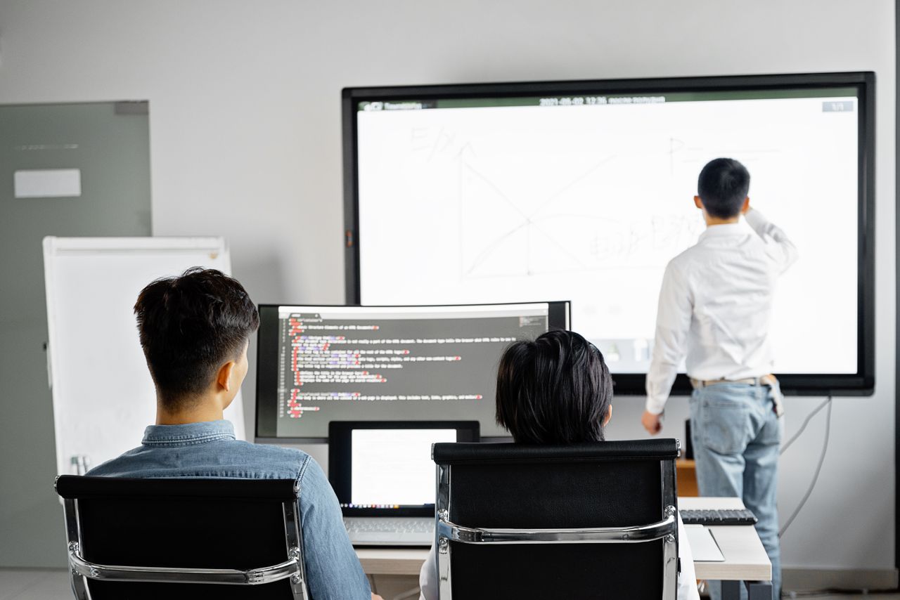 Mastering the First Impression: Your intriguing post title goes here Team conducting a business presentation with technology in a modern office setting.